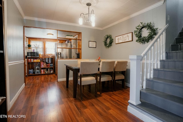 dining area featuring crown molding, dark wood-type flooring, and a notable chandelier