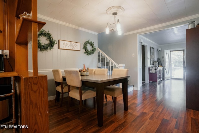 dining space with dark hardwood / wood-style flooring, an inviting chandelier, and ornamental molding