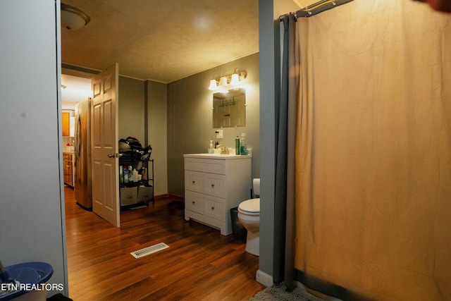 bathroom featuring vanity, wood-type flooring, and toilet