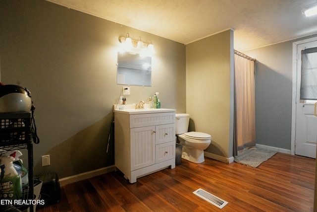 bathroom featuring toilet, vanity, and hardwood / wood-style flooring