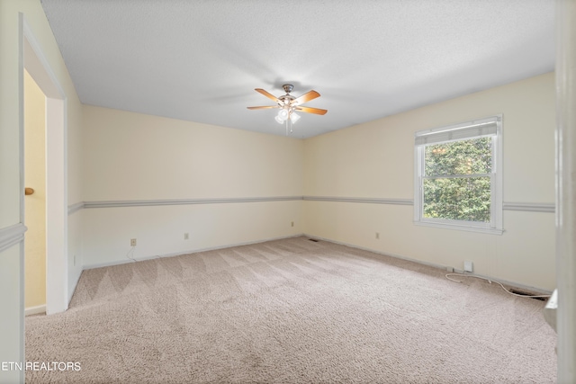 carpeted empty room featuring a textured ceiling and ceiling fan