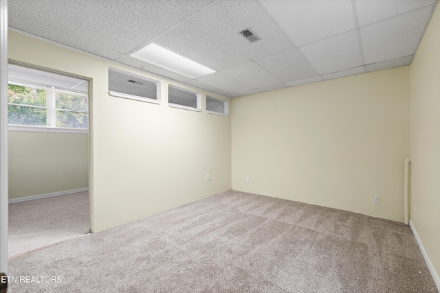 spare room featuring carpet floors and a paneled ceiling