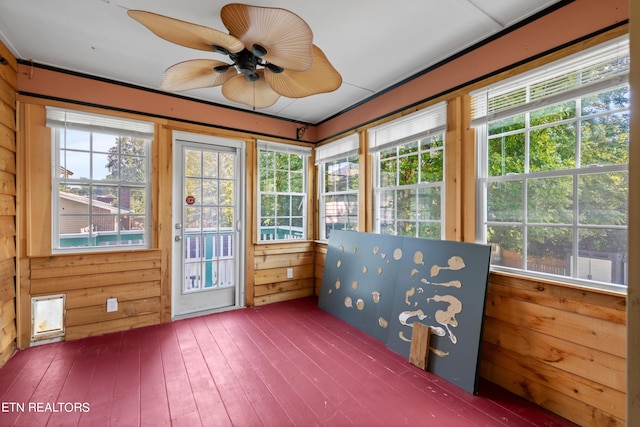 unfurnished sunroom featuring ceiling fan