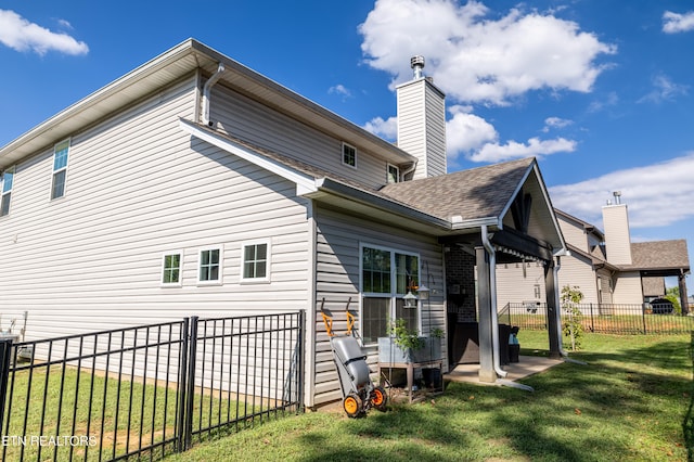 rear view of house featuring a patio and a yard