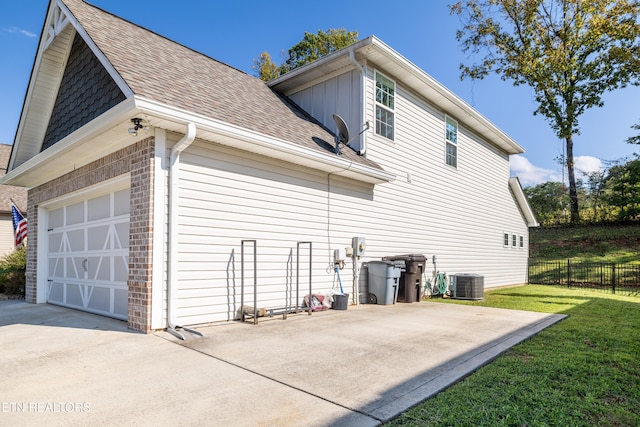 view of home's exterior with a lawn, cooling unit, and a garage