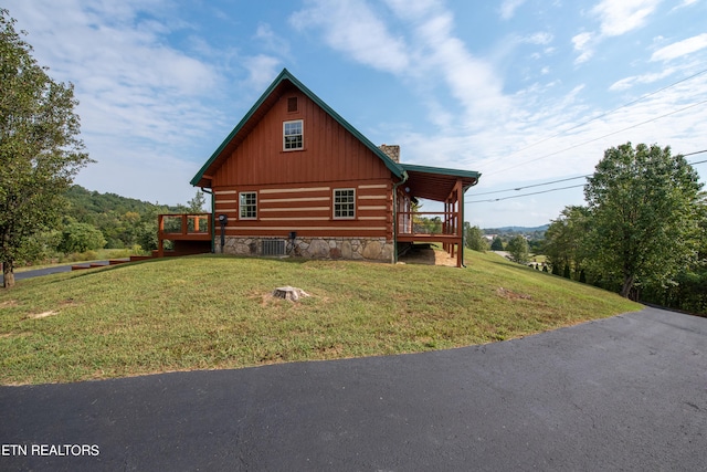 view of home's exterior with cooling unit, a wooden deck, and a yard