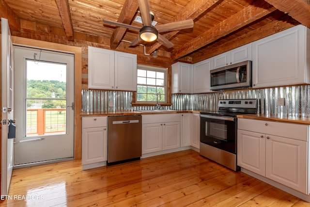 kitchen with stainless steel appliances, white cabinetry, light hardwood / wood-style floors, and sink