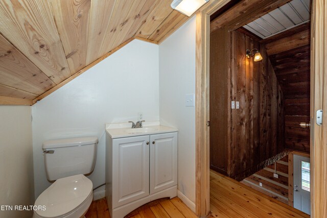 bathroom featuring wood ceiling, hardwood / wood-style flooring, vanity, and toilet