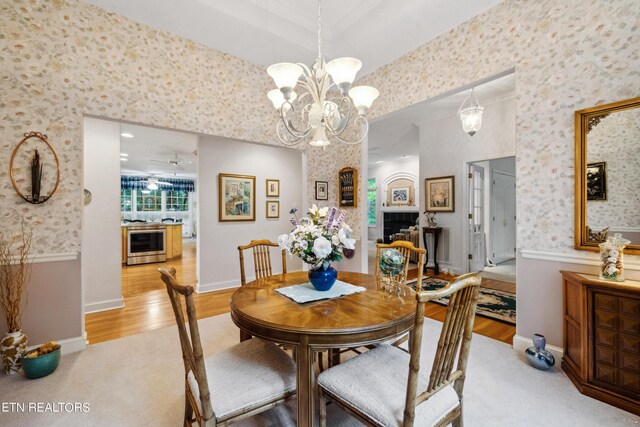 122 Vinita Ln, Loudon, TN 37774 - dining area with wallpapered walls, light wood-type flooring, light carpet, and a notable chandelier