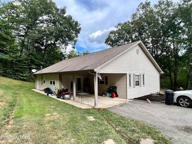 view of side of property featuring a patio area and a yard