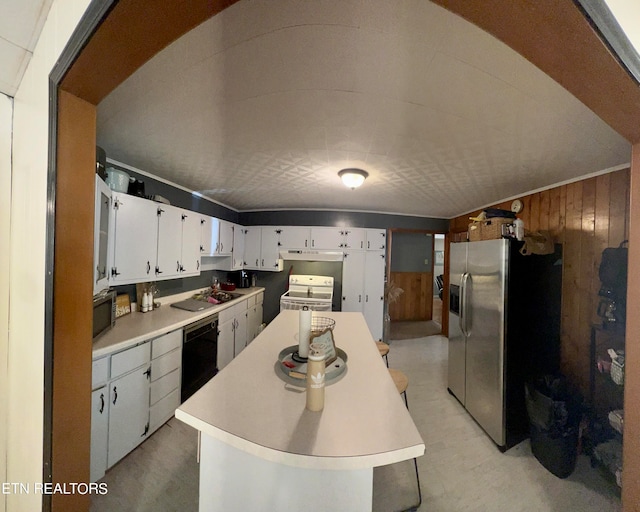 kitchen with white cabinets, wood walls, a center island, and stainless steel appliances