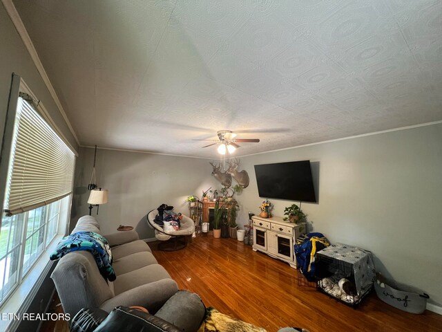 living room with ceiling fan, hardwood / wood-style flooring, crown molding, and a textured ceiling