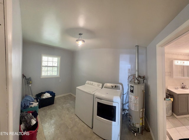 clothes washing area featuring separate washer and dryer and water heater