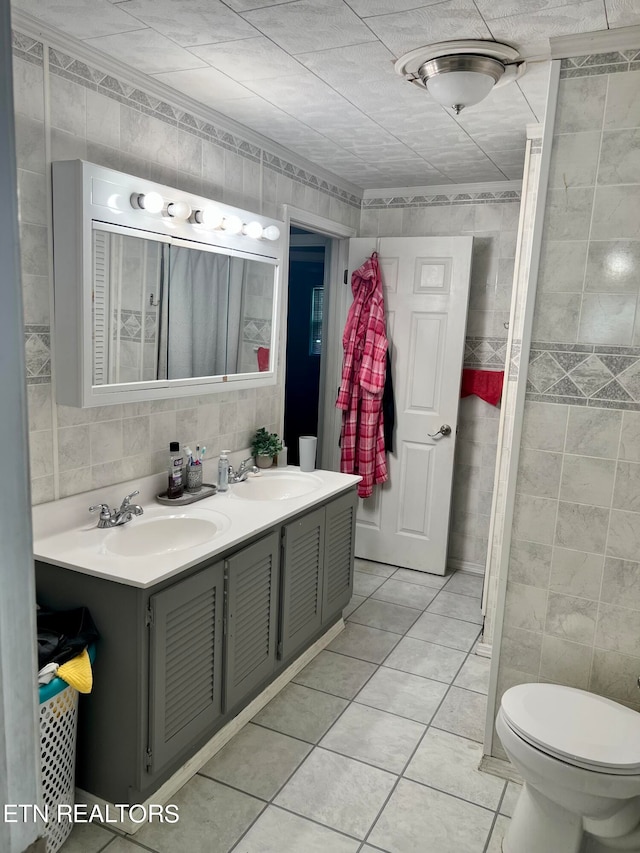 bathroom featuring tile walls, vanity, toilet, and tile patterned floors