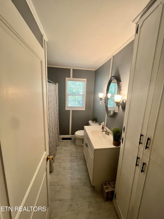 bathroom with a shower with curtain, vanity, crown molding, and toilet