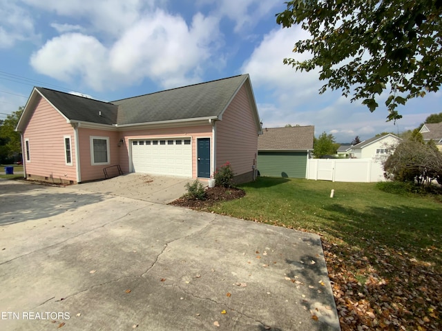 view of side of home with a garage and a lawn