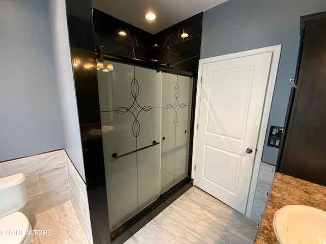 bathroom featuring toilet, vanity, and walk in shower