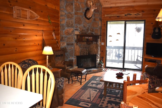 tiled living room featuring a stone fireplace and lofted ceiling