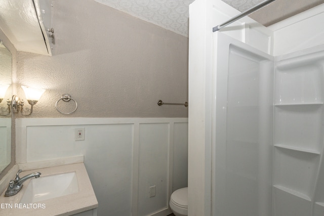 bathroom featuring vanity, a shower, and toilet