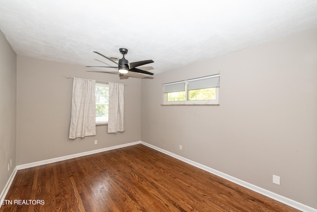 empty room featuring dark hardwood / wood-style flooring and ceiling fan