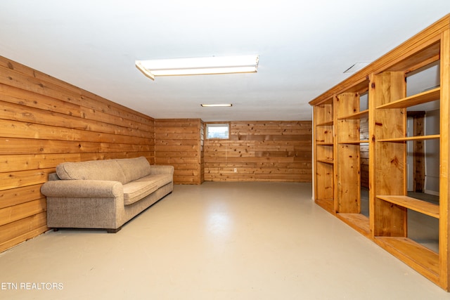 sitting room with concrete flooring and wood walls