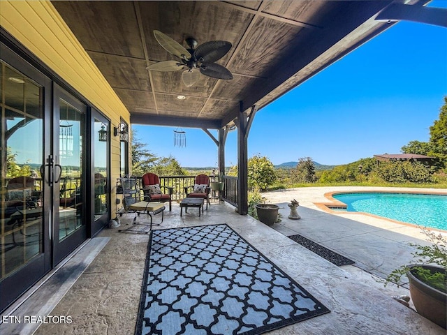 view of patio with ceiling fan and a fenced in pool