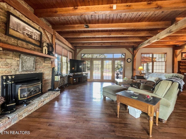 unfurnished living room featuring a fireplace, beamed ceiling, french doors, and plenty of natural light