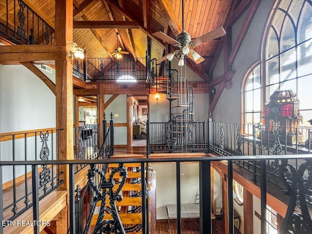 interior space with ceiling fan, beamed ceiling, wood-type flooring, high vaulted ceiling, and wooden ceiling