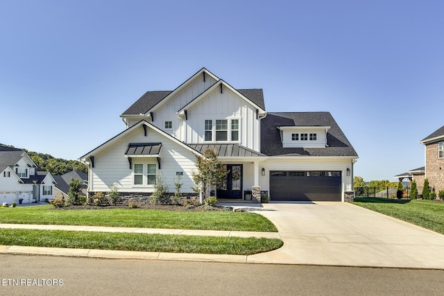 view of front of property with board and batten siding, french doors, a front yard, fence, and concrete driveway
