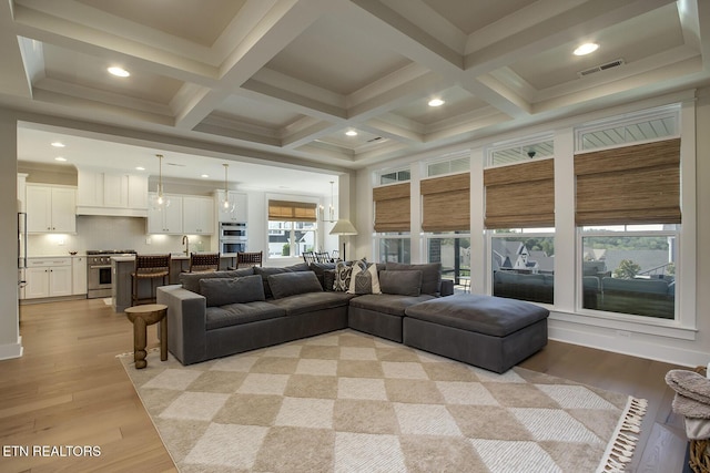 living area featuring recessed lighting, beamed ceiling, visible vents, and light wood-type flooring
