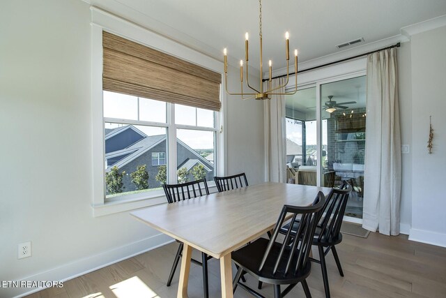 dining room with visible vents, baseboards, ceiling fan with notable chandelier, and wood finished floors