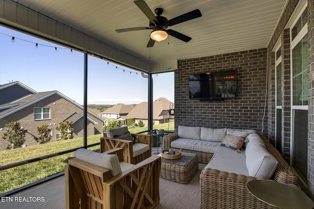 sunroom with a residential view, a ceiling fan, and an outdoor hangout area