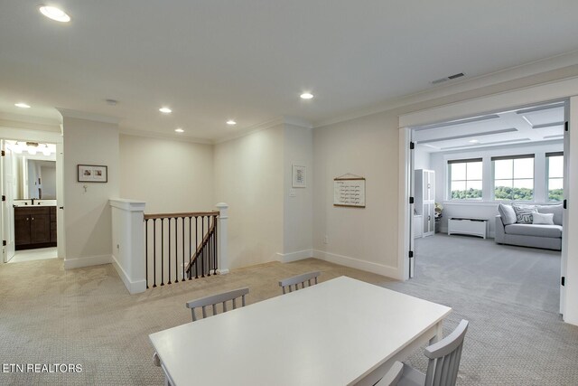 hall featuring visible vents, ornamental molding, an upstairs landing, and light carpet