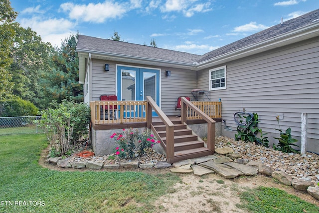 back of house with a wooden deck and a yard