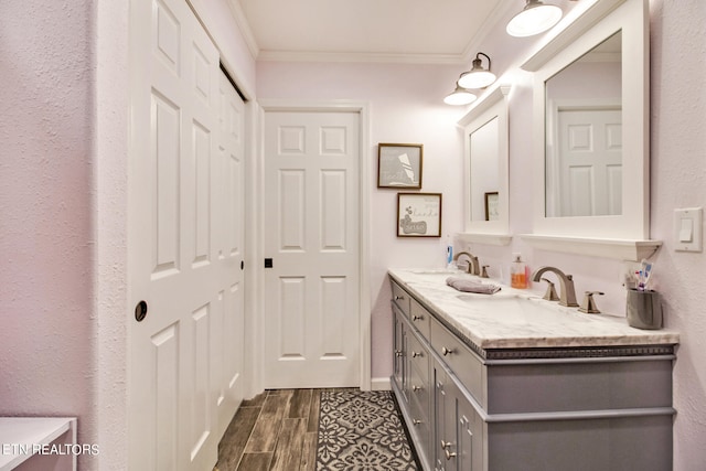 bathroom featuring wood-type flooring, vanity, and crown molding