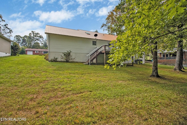 back of house with a yard, metal roof, a wooden deck, and stairway