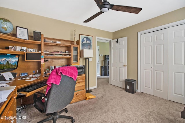 carpeted office space with a ceiling fan