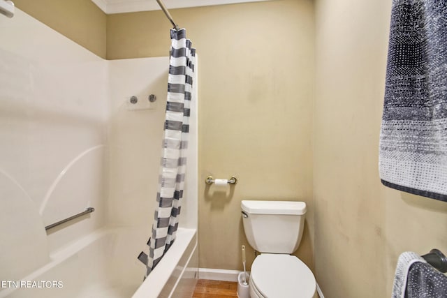 bathroom with hardwood / wood-style floors, toilet, and shower / bathtub combination with curtain