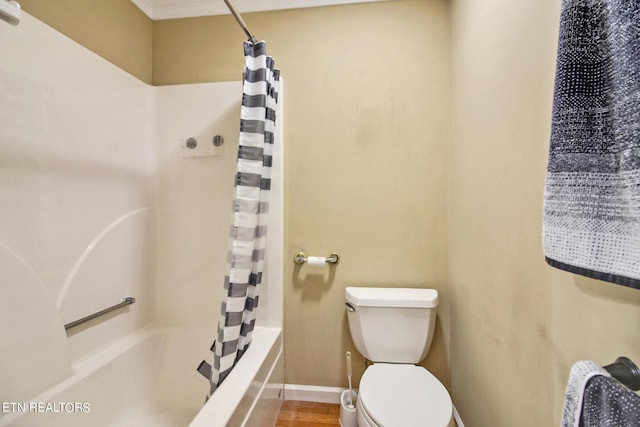 bathroom featuring toilet, shower / bath combo with shower curtain, wood finished floors, and baseboards