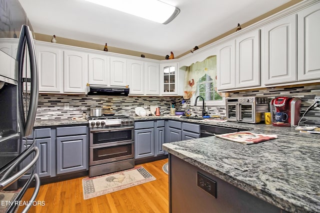 kitchen with exhaust hood, a sink, double oven range, gray cabinetry, and refrigerator with ice dispenser