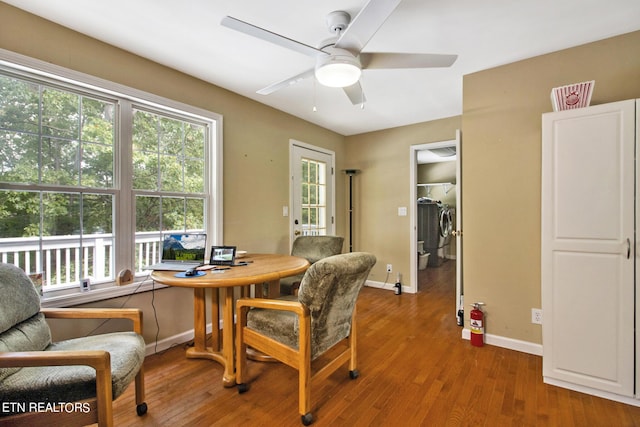 dining area with washing machine and dryer, baseboards, wood finished floors, and ceiling fan