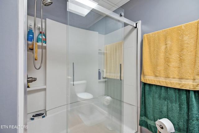 bathroom featuring walk in shower, ornamental molding, and toilet