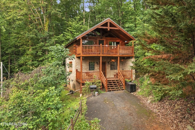 log-style house with a wooden deck and central AC unit