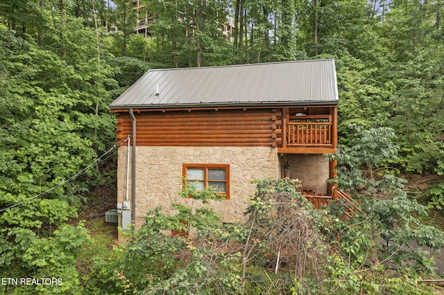 view of property exterior featuring a balcony and central AC