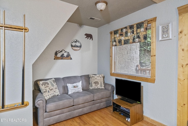 living room featuring a textured ceiling and hardwood / wood-style floors