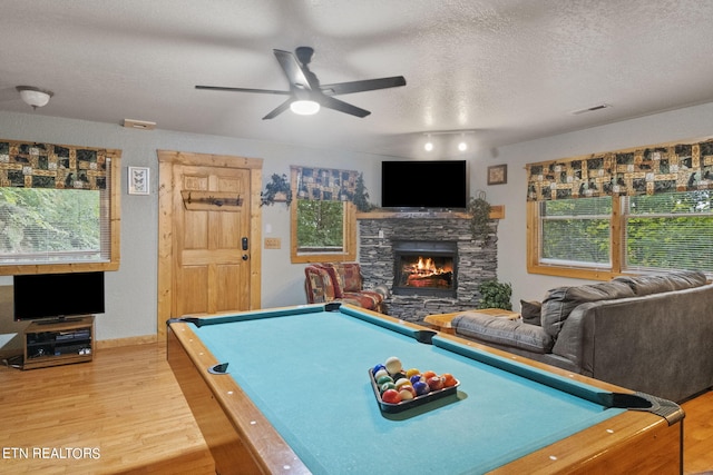 game room with ceiling fan, a textured ceiling, pool table, a fireplace, and hardwood / wood-style floors