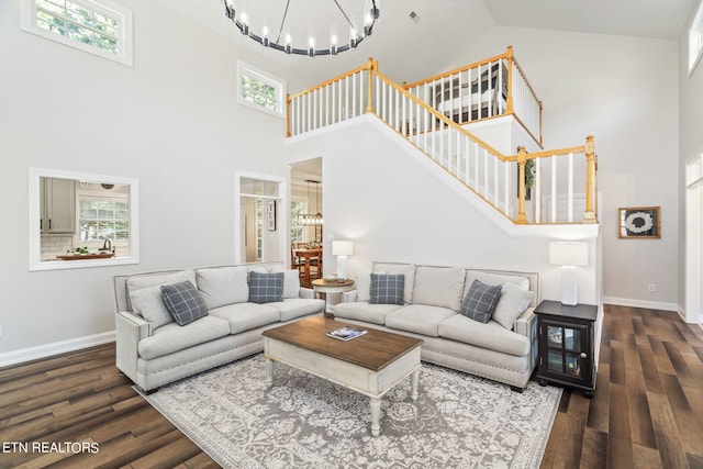 living room with a notable chandelier, dark wood-type flooring, and high vaulted ceiling