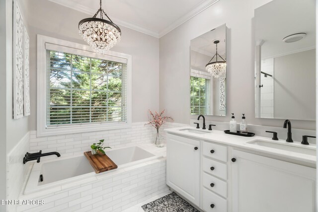 bathroom with tiled tub, an inviting chandelier, tile patterned floors, ornamental molding, and vanity