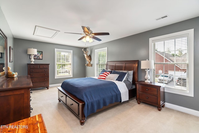 bedroom with multiple windows, light colored carpet, and ceiling fan