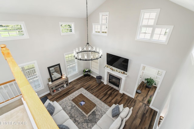 living room featuring dark hardwood / wood-style floors, a chandelier, and high vaulted ceiling